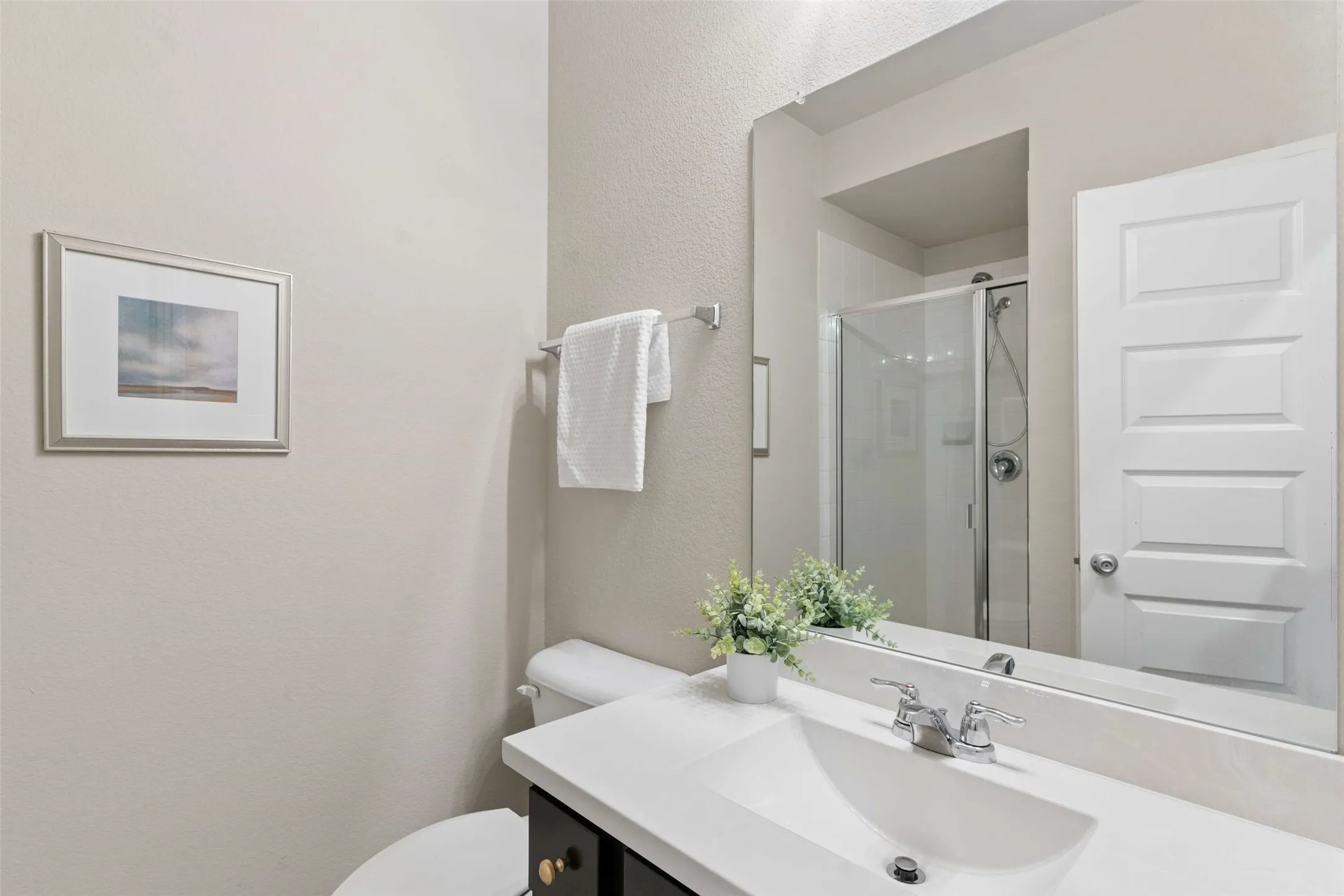 Vanity featuring an integrated sink, polished chrome faucet, and a large wall-mounted mirror