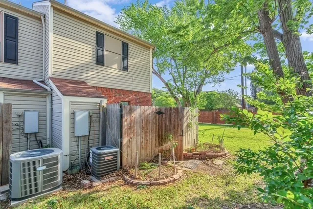 Siding exterior with brick accents, wood fencing, and established trees