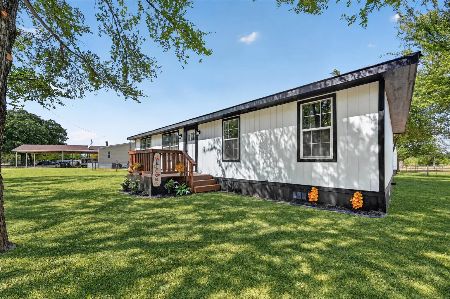 Grass is AI. White vertical siding exterior with black trim and white-framed windows