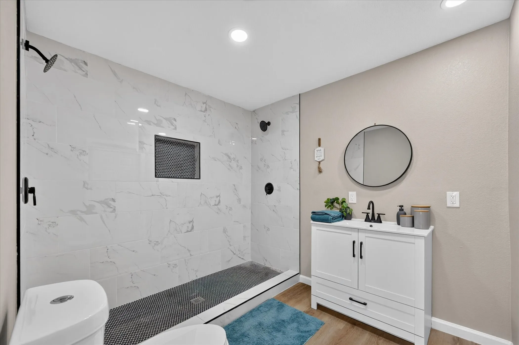 Bathroom #2 Walk-in shower with large format wall tile, black-tiled shower floor, and built-in shower niche