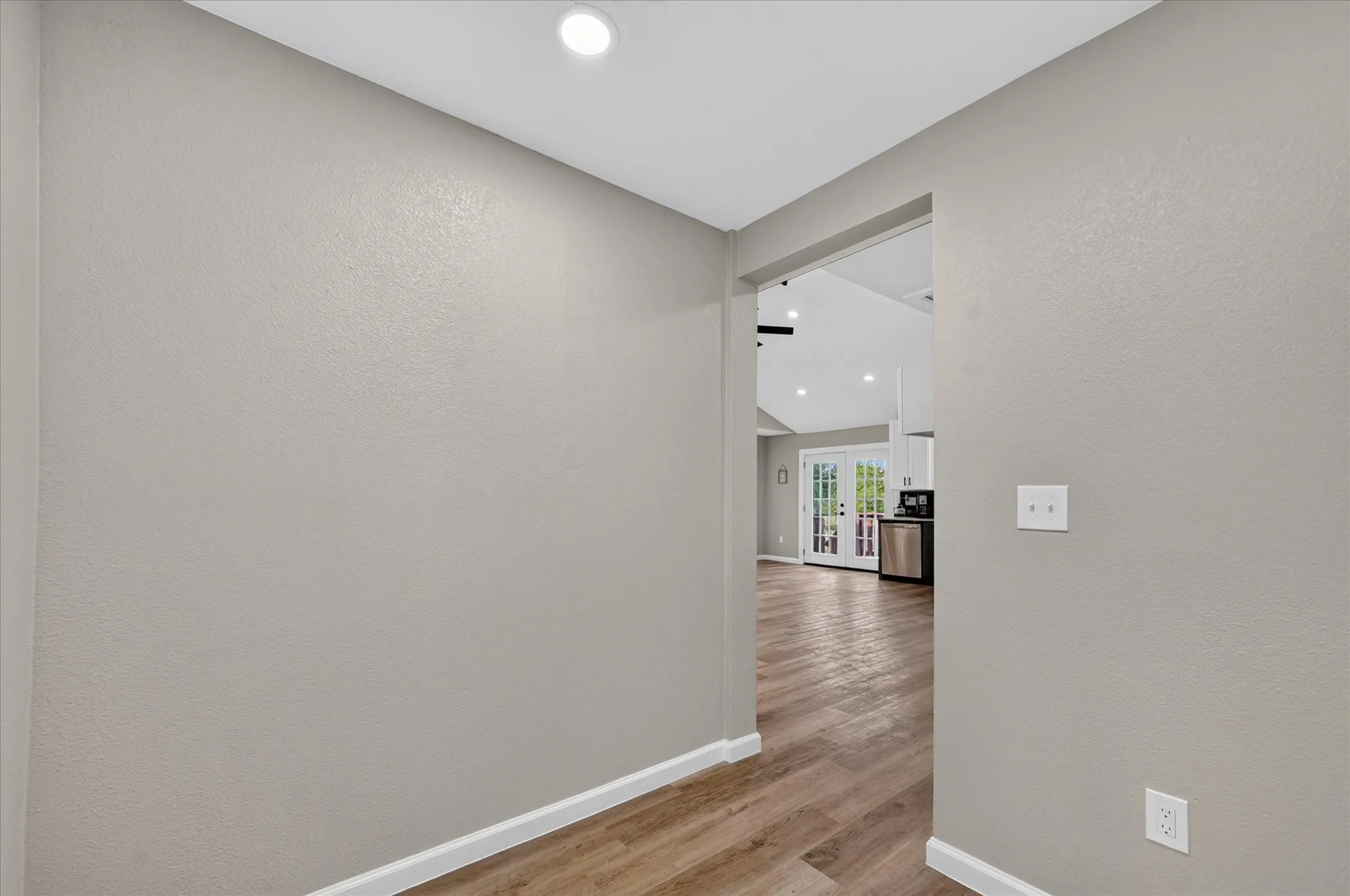 Recessed ceiling lighting, wood-finish flooring, white baseboards, and neutral wall tones