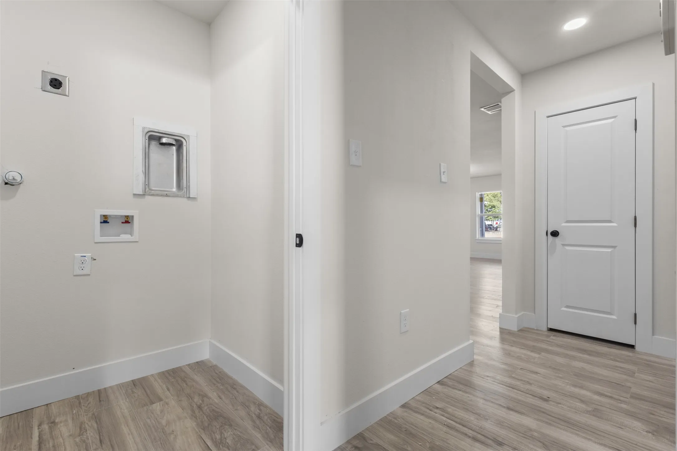 Laundry area with connections and wood-finish flooring