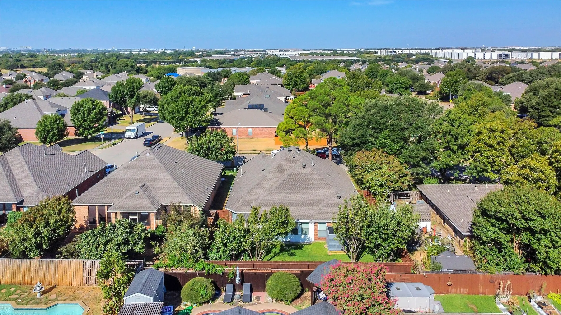 Residential neighborhood featuring mature trees, a private fenced yard, an in-ground pool, and a storage shed