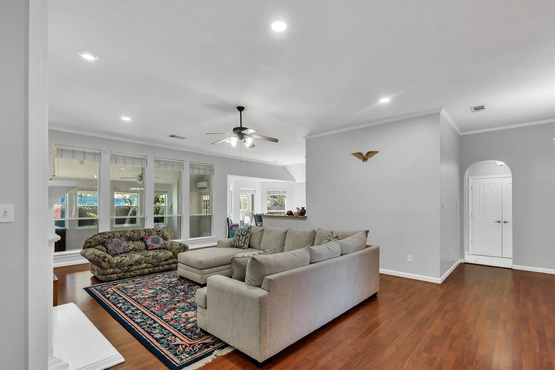 Spacious living area featuring wood-finish flooring, recessed lighting, and a ceiling fan