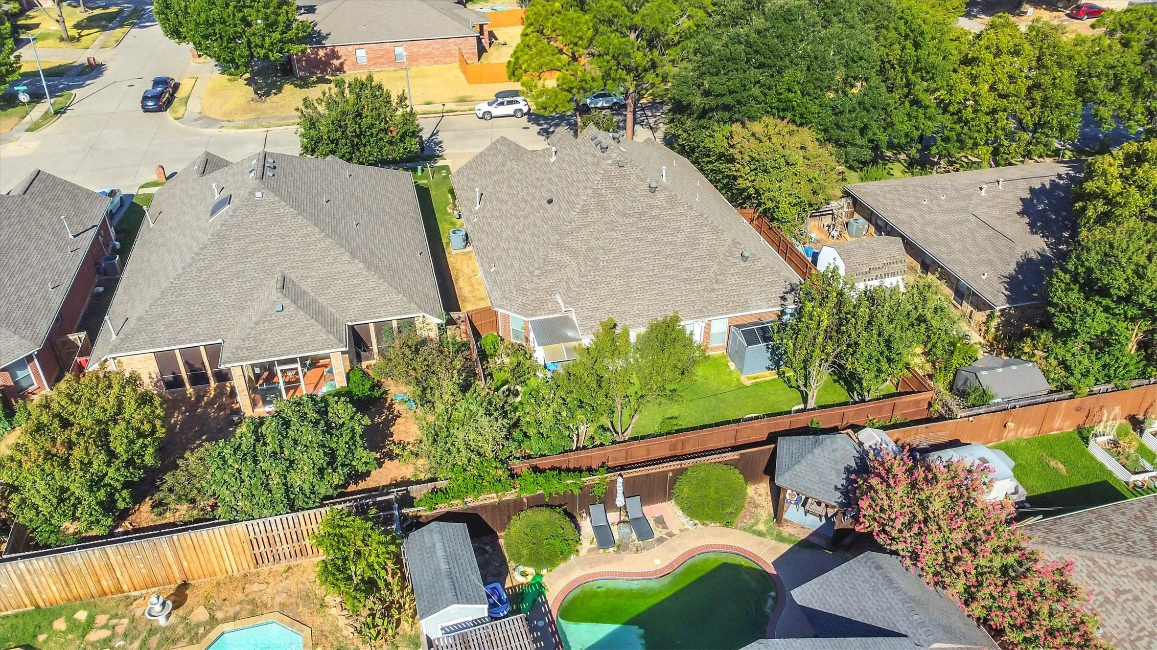 Expansive fenced backyard with mature trees, providing privacy