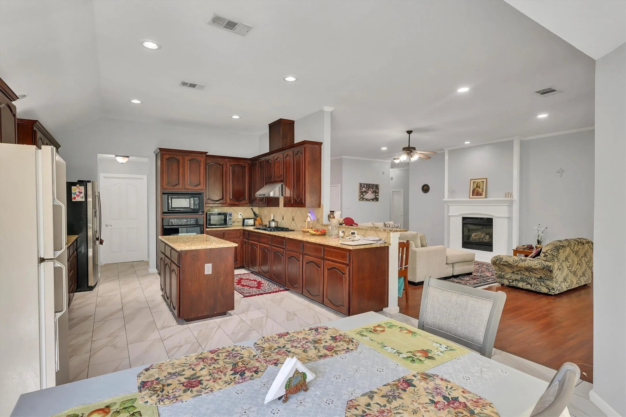 Kitchen with dark wood cabinetry, light-toned countertops, and tile flooring