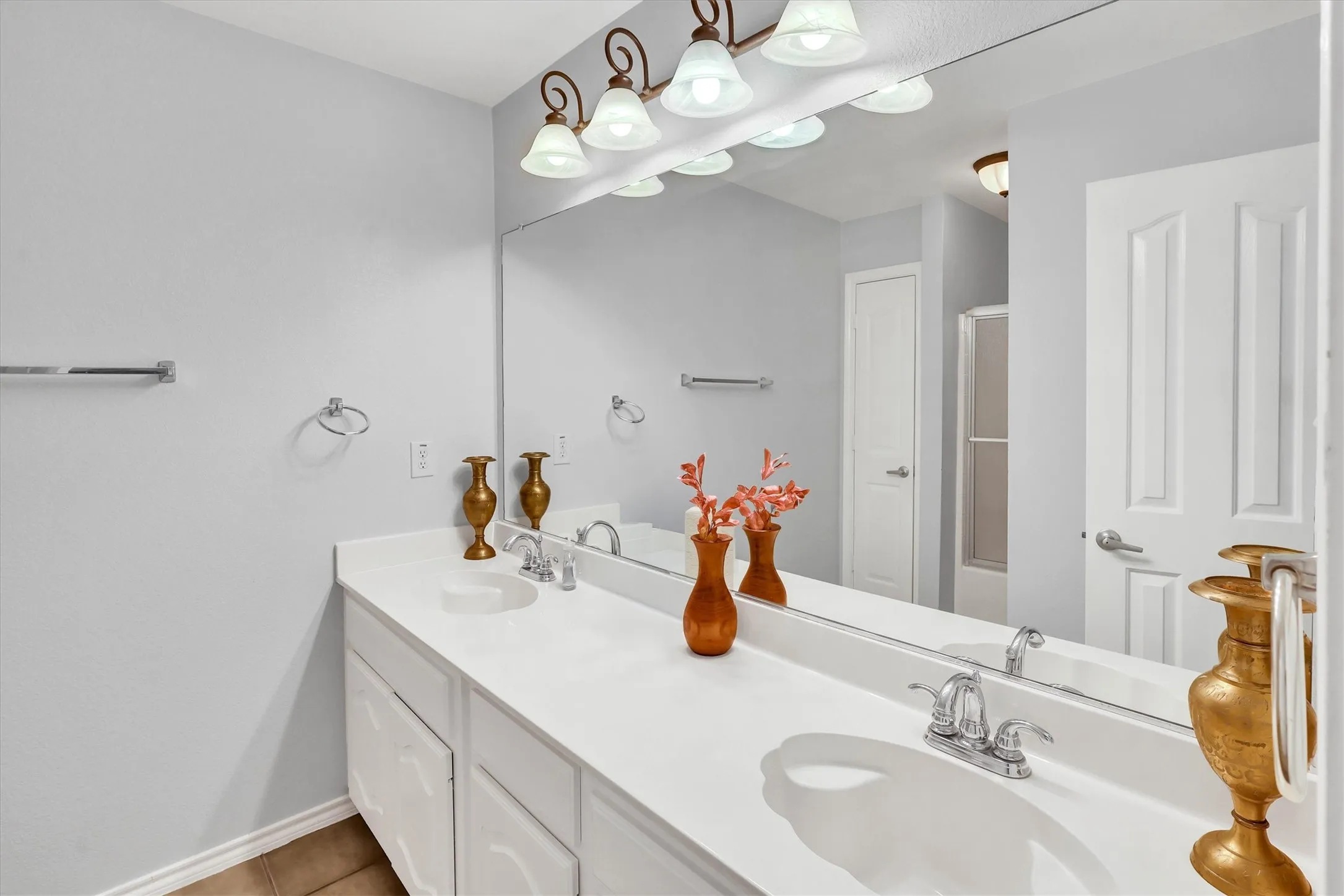 Dual vanity with integrated sinks, chrome faucets, and a full-width mirror