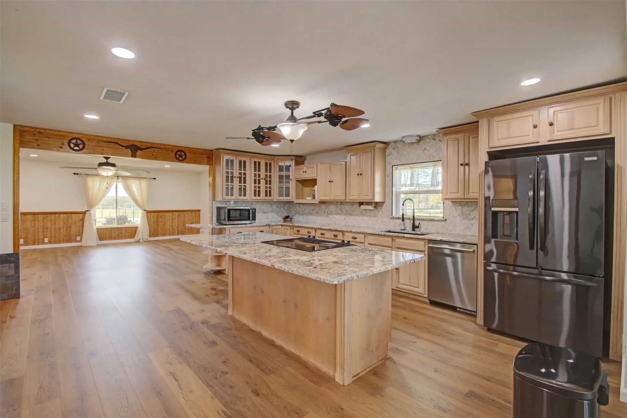 Recently remodeled kitchen has almost new appliances, granite counter tops and a very unique fan and light combination. You could probably seat 4/5 people ere  The open concept is definitely on display here.