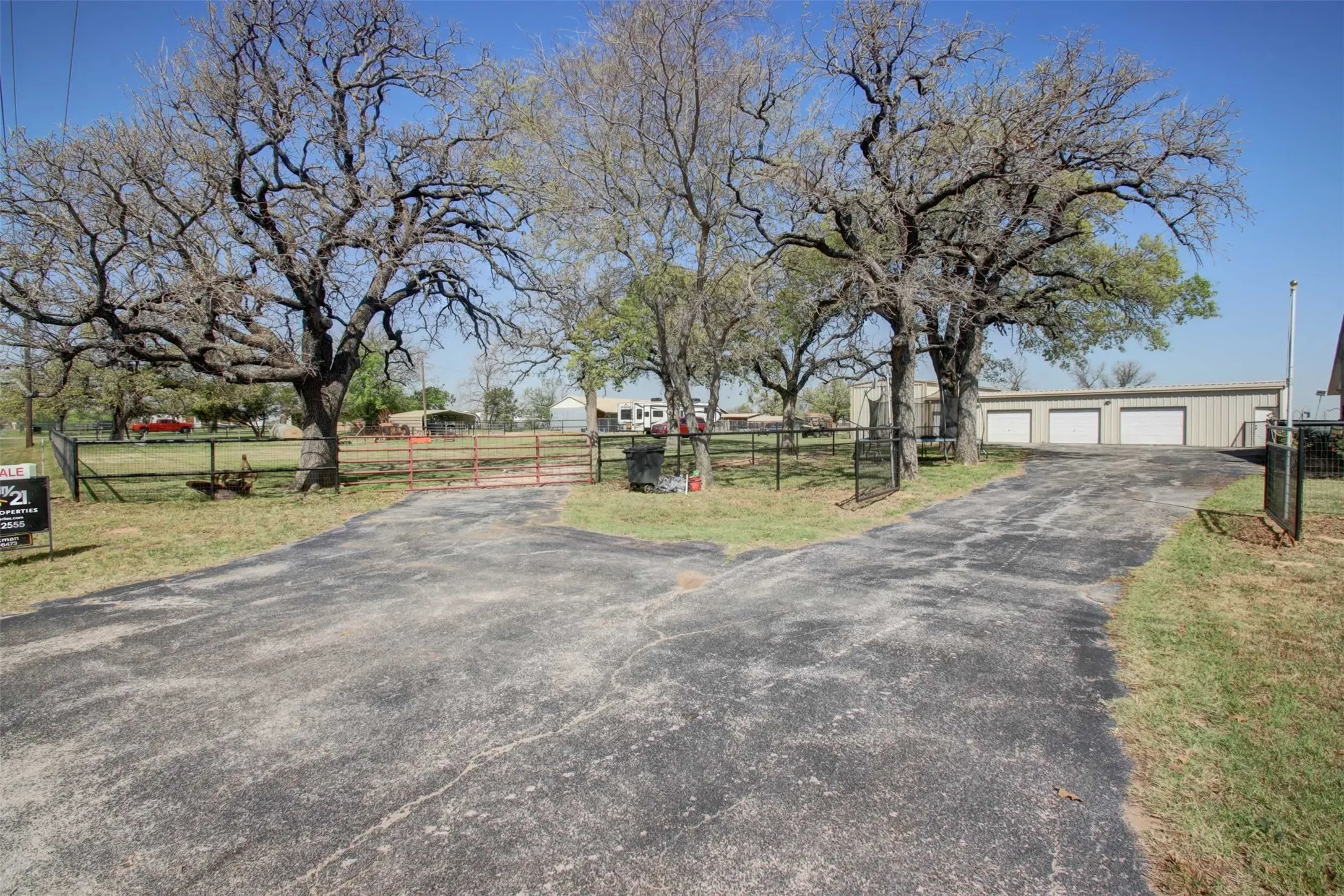 Access the home and 4 car garage through the double wrought iron gates. To enter the barn area and the RV garage go through the metal gate to the left.