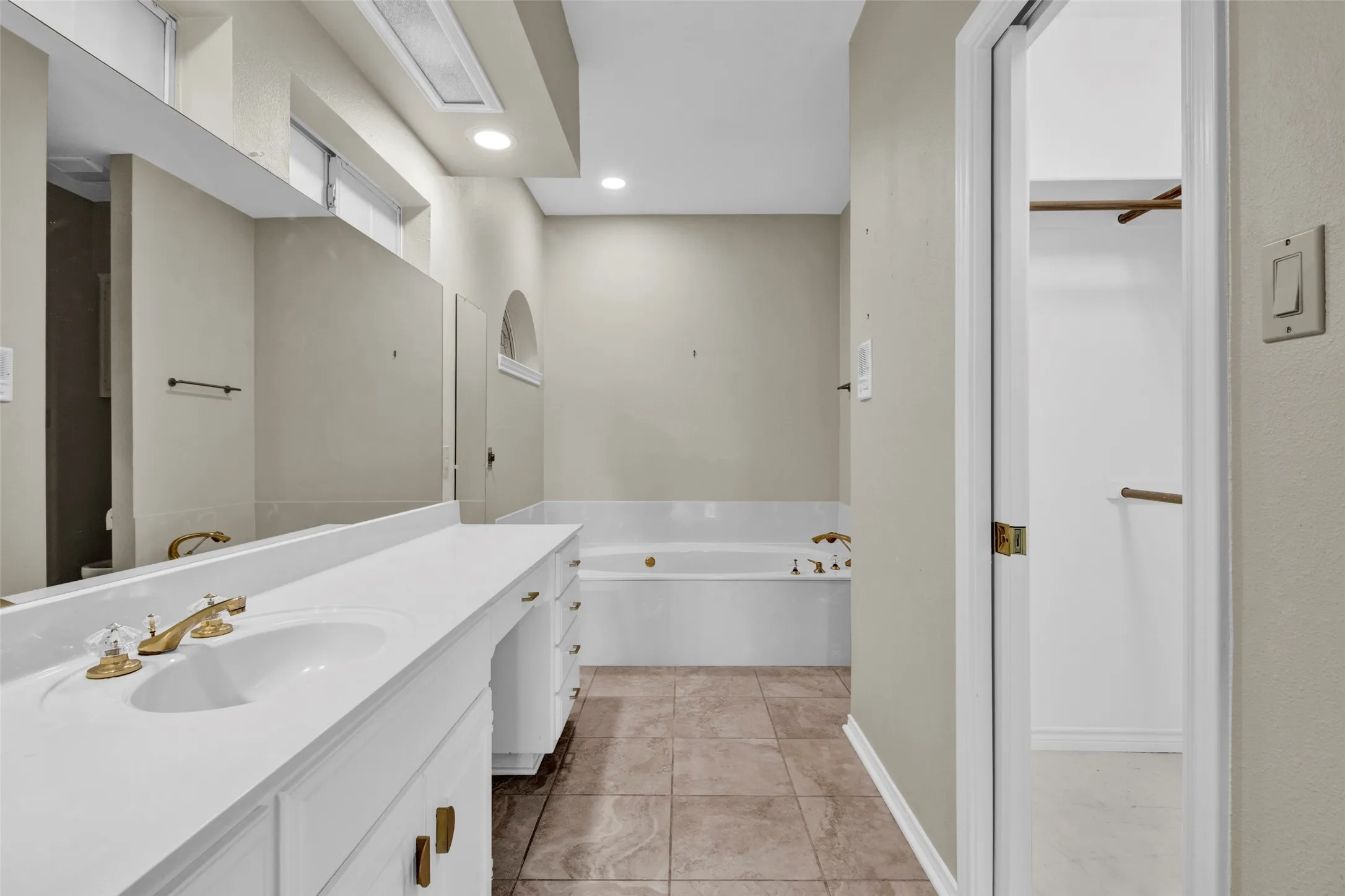 Vanity with integrated sink and brass-finish faucet, along with a built-in bathtub