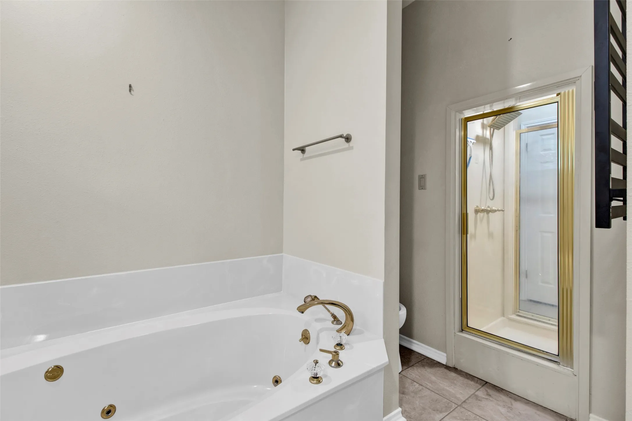 White jetted soaking tub with brass fixtures