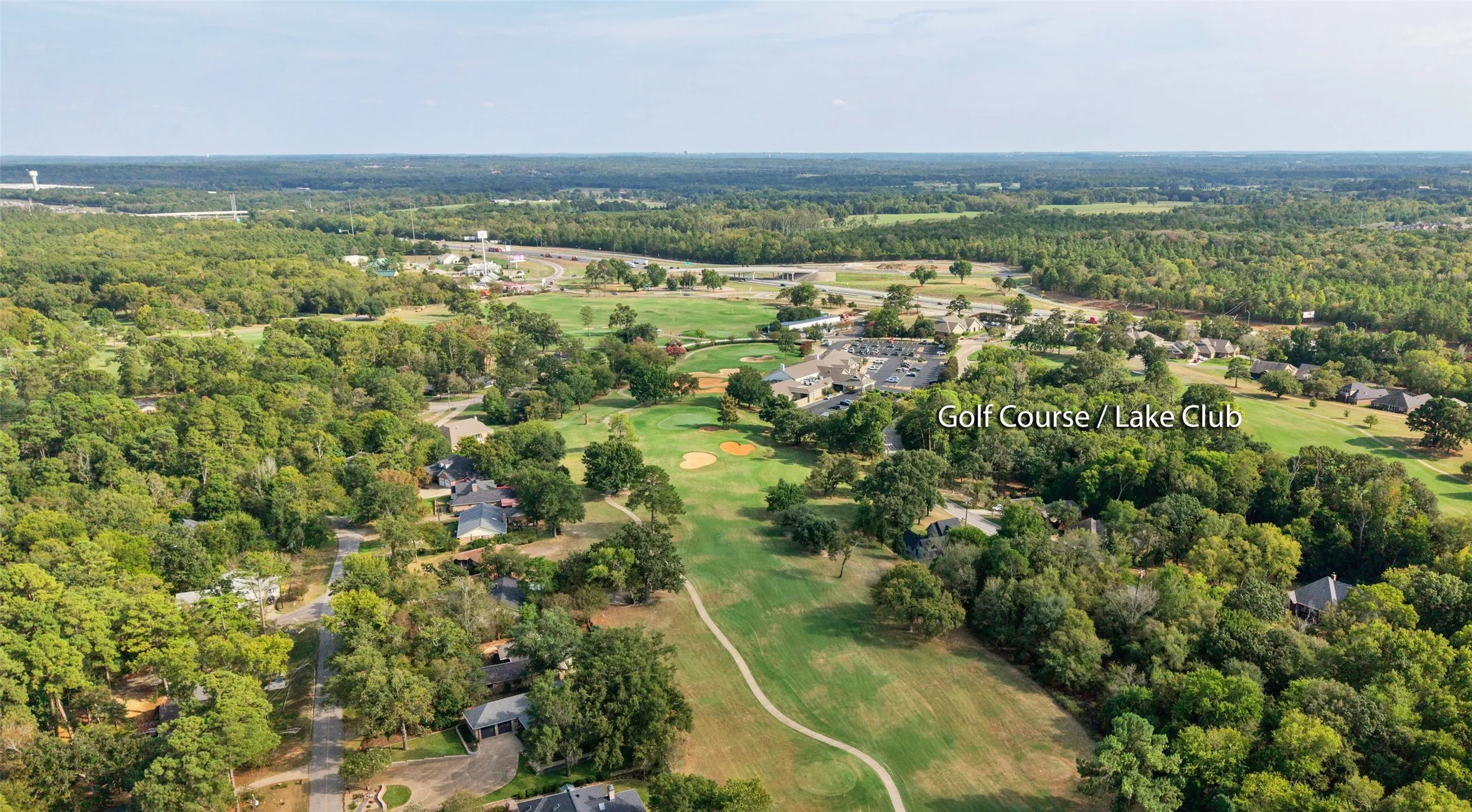 Aerial perspective of a golf course community with extensive tree coverage