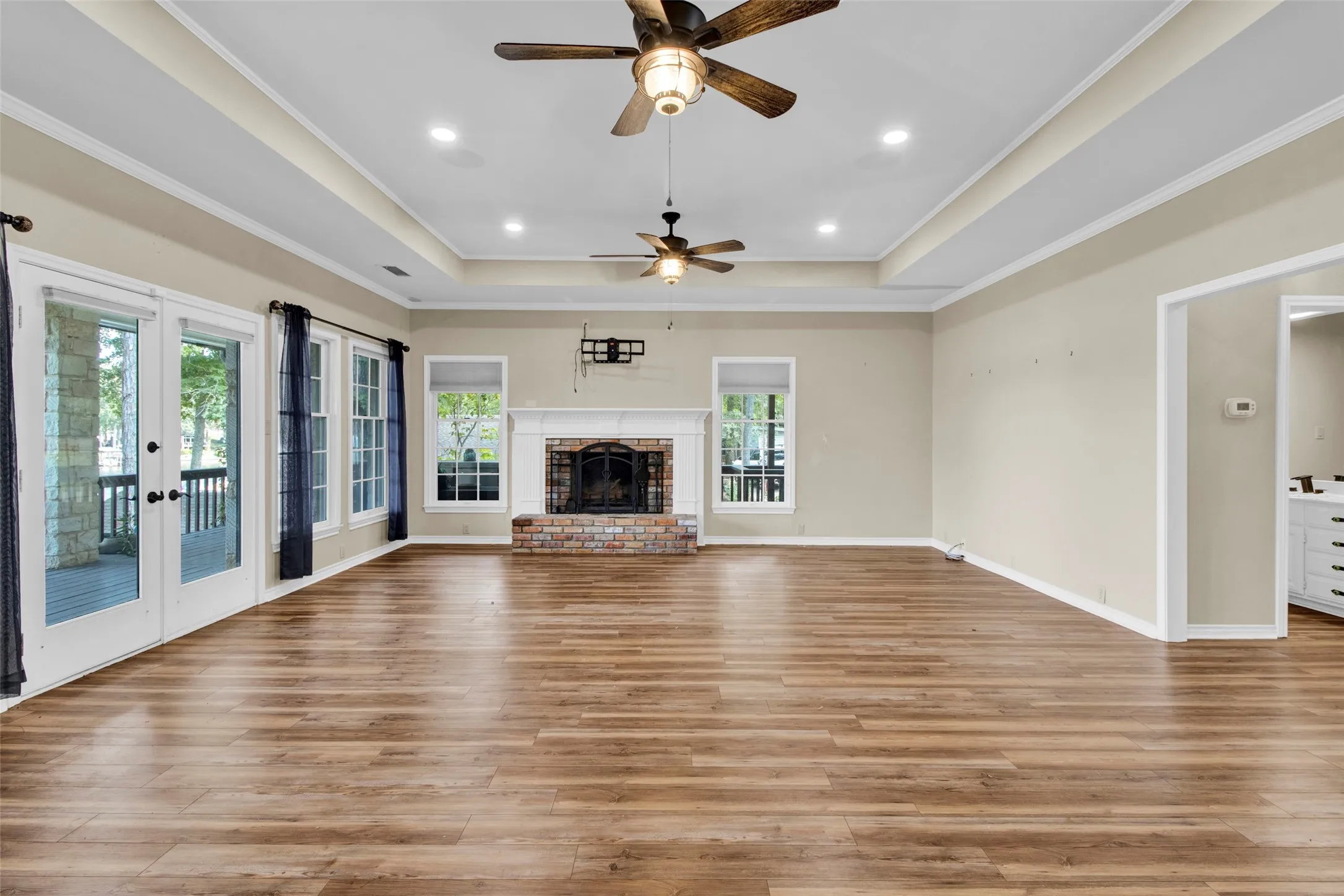 Wood-finish flooring, recessed lighting, and a tray ceiling