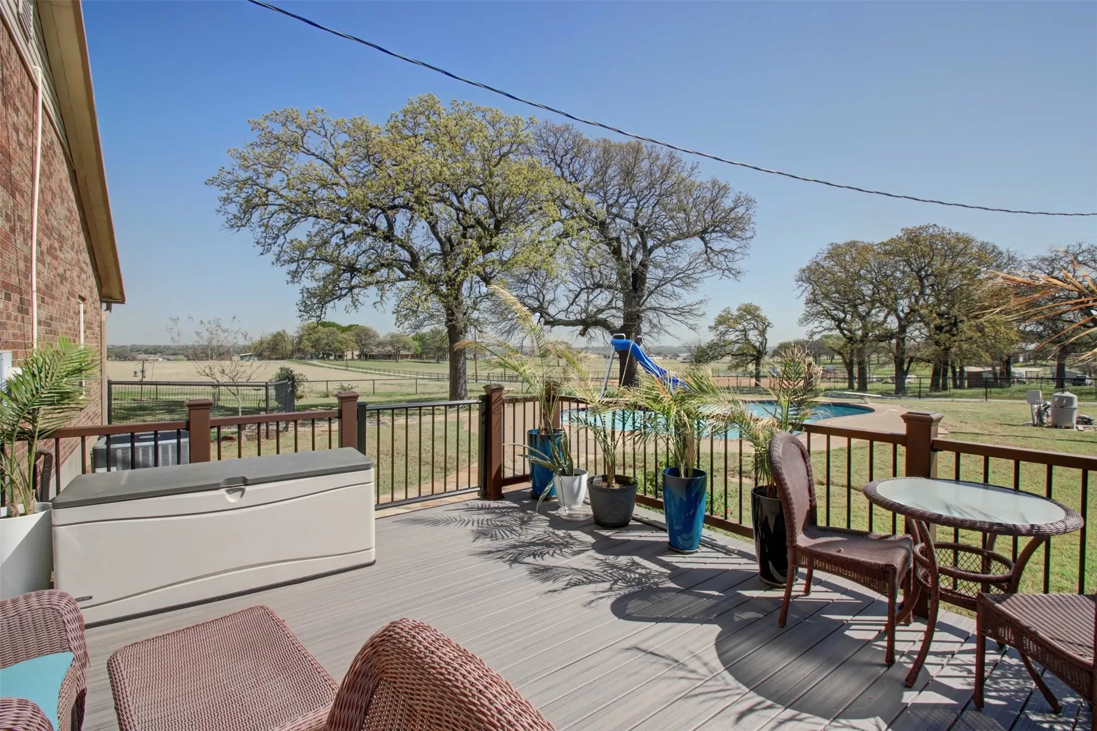 This is the deck off the primary bedroom with a great view of the pool and open pastures.