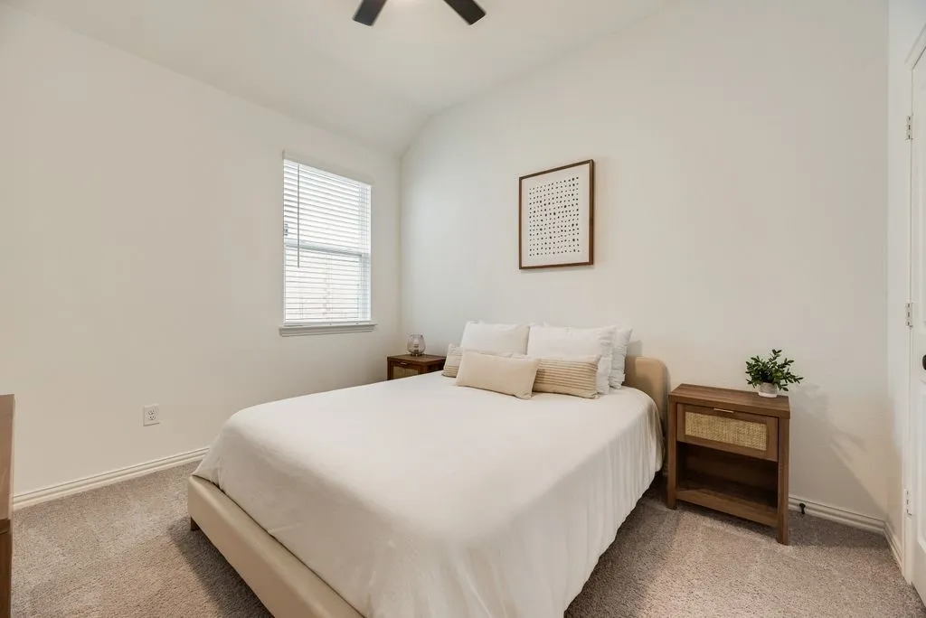 Vaulted ceiling with a ceiling fan, window with blinds, and neutral carpeting