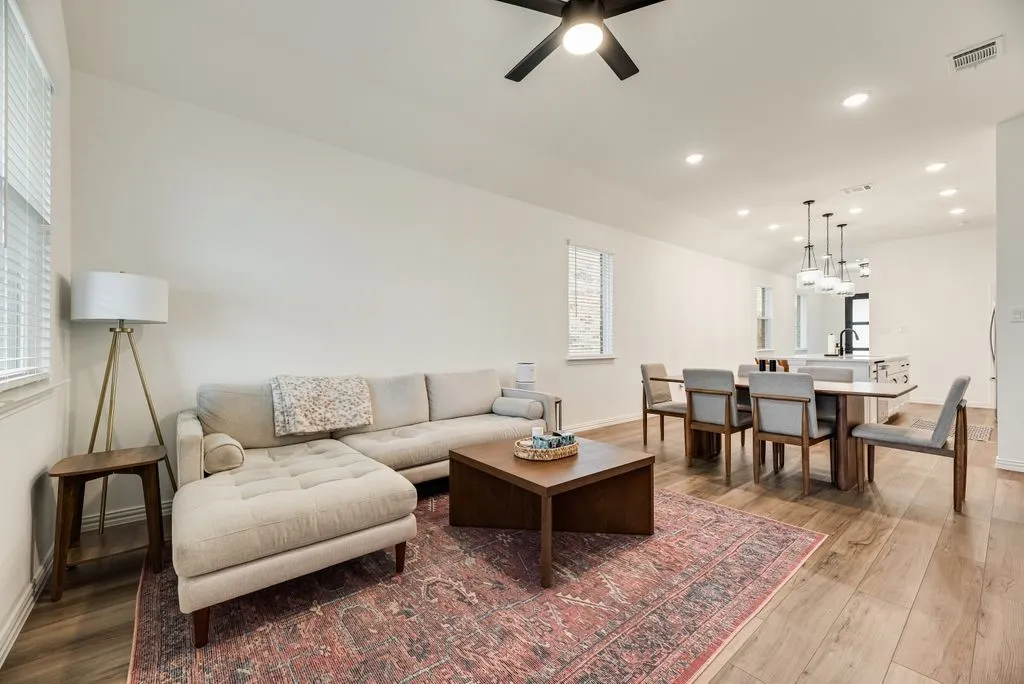 Open-concept living area featuring wood-finish flooring, recessed lighting, and a ceiling fan