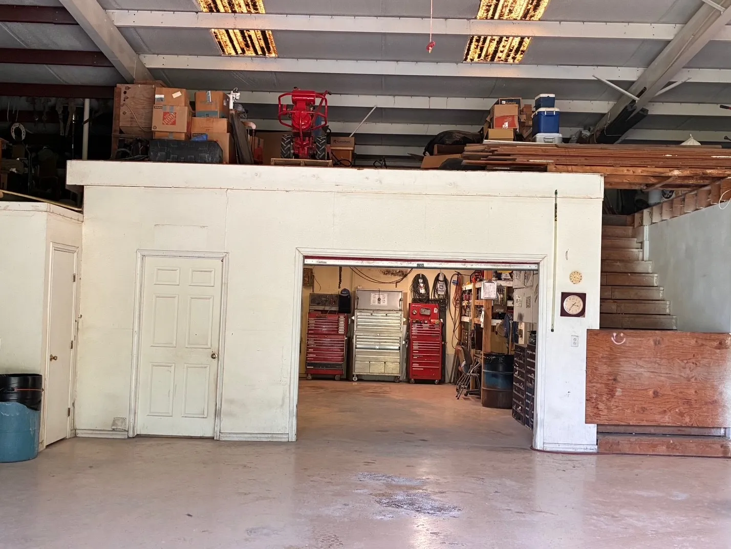 Concrete flooring, exposed ceiling beams, recessed lighting, interior staircase, and a built-in storage loft