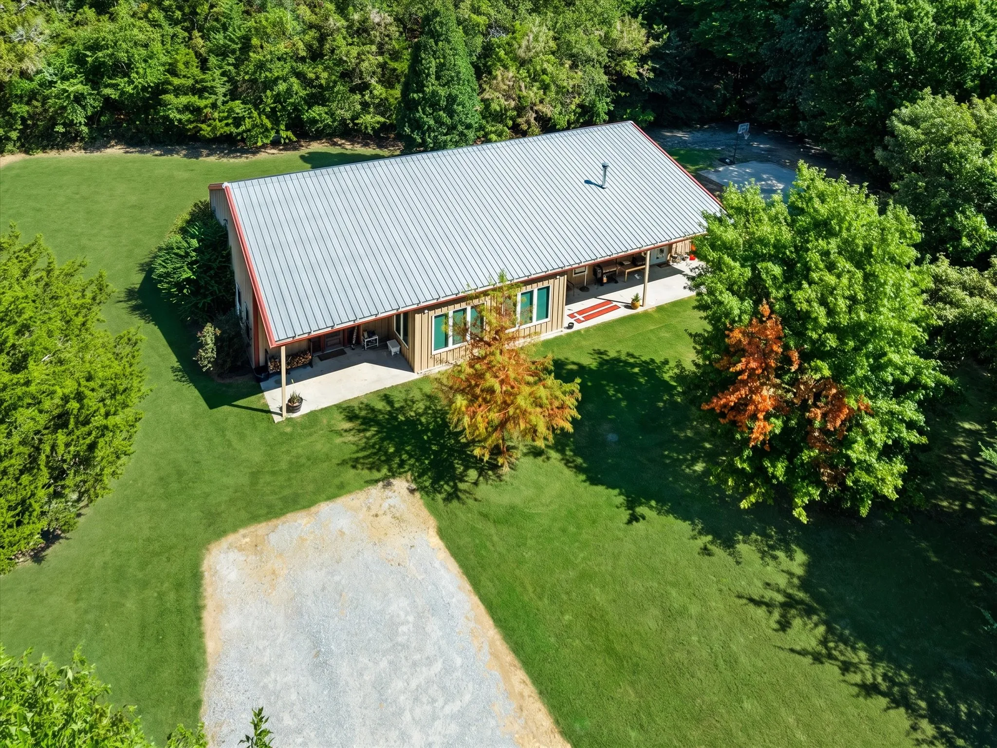 Expansive green lawn surrounding a residence with a metal roof and wood exterior