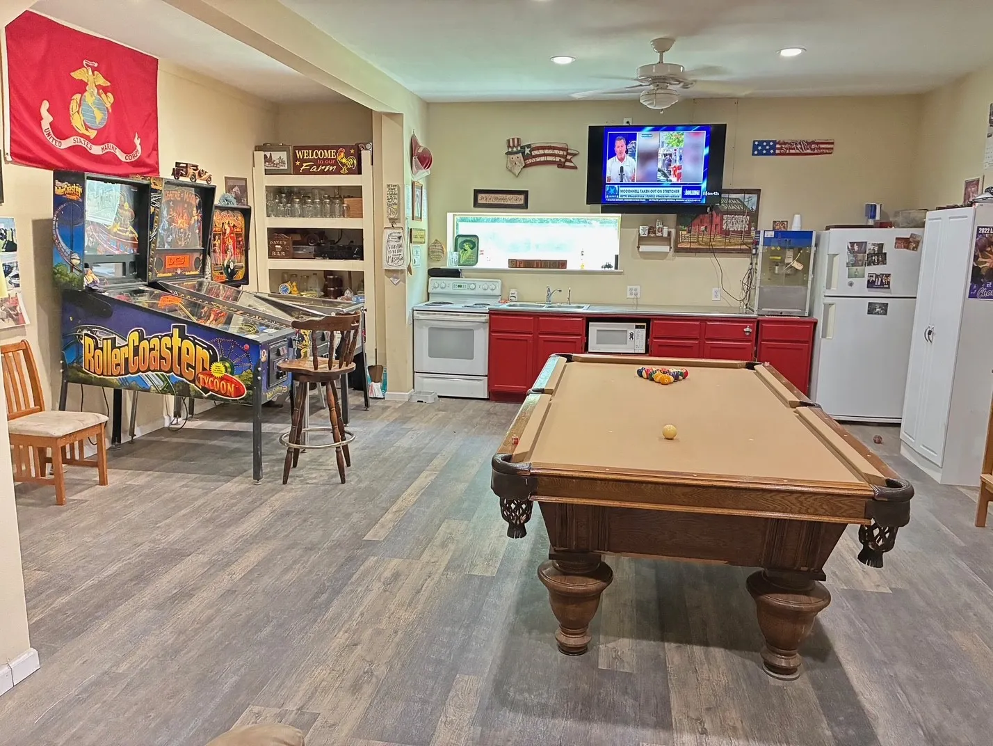 Wood-finish flooring, recessed lighting, ceiling fan, built-in shelving, red lower cabinetry, and white appliances