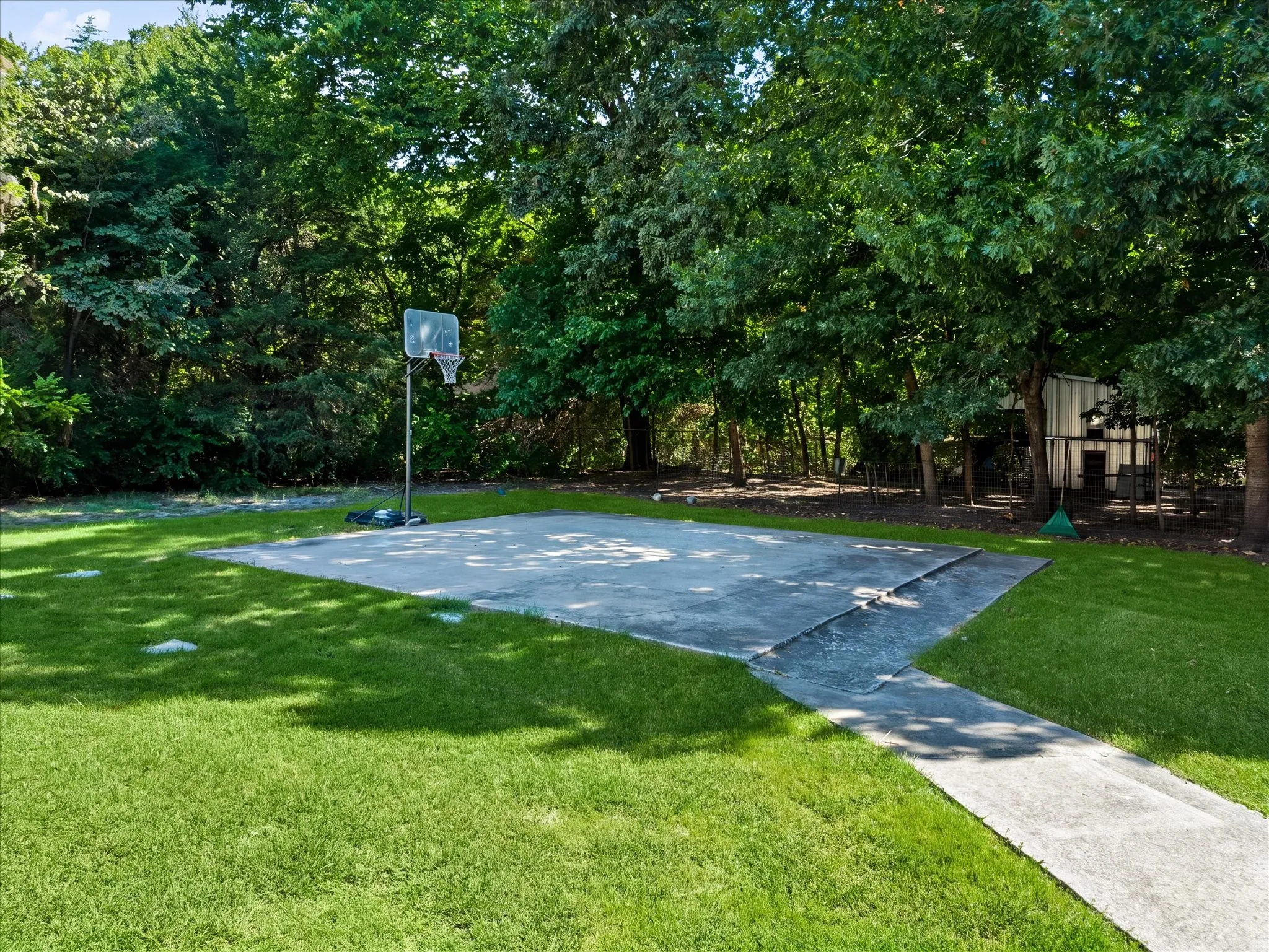 Expansive lawn featuring a concrete patio and a paved pathway