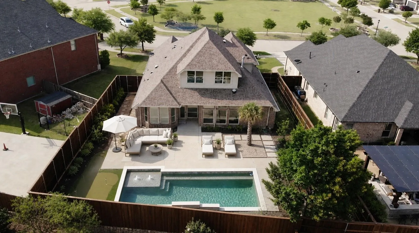 Backyard featuring a rectangular swimming pool with water features, a concrete patio, and a privacy fence