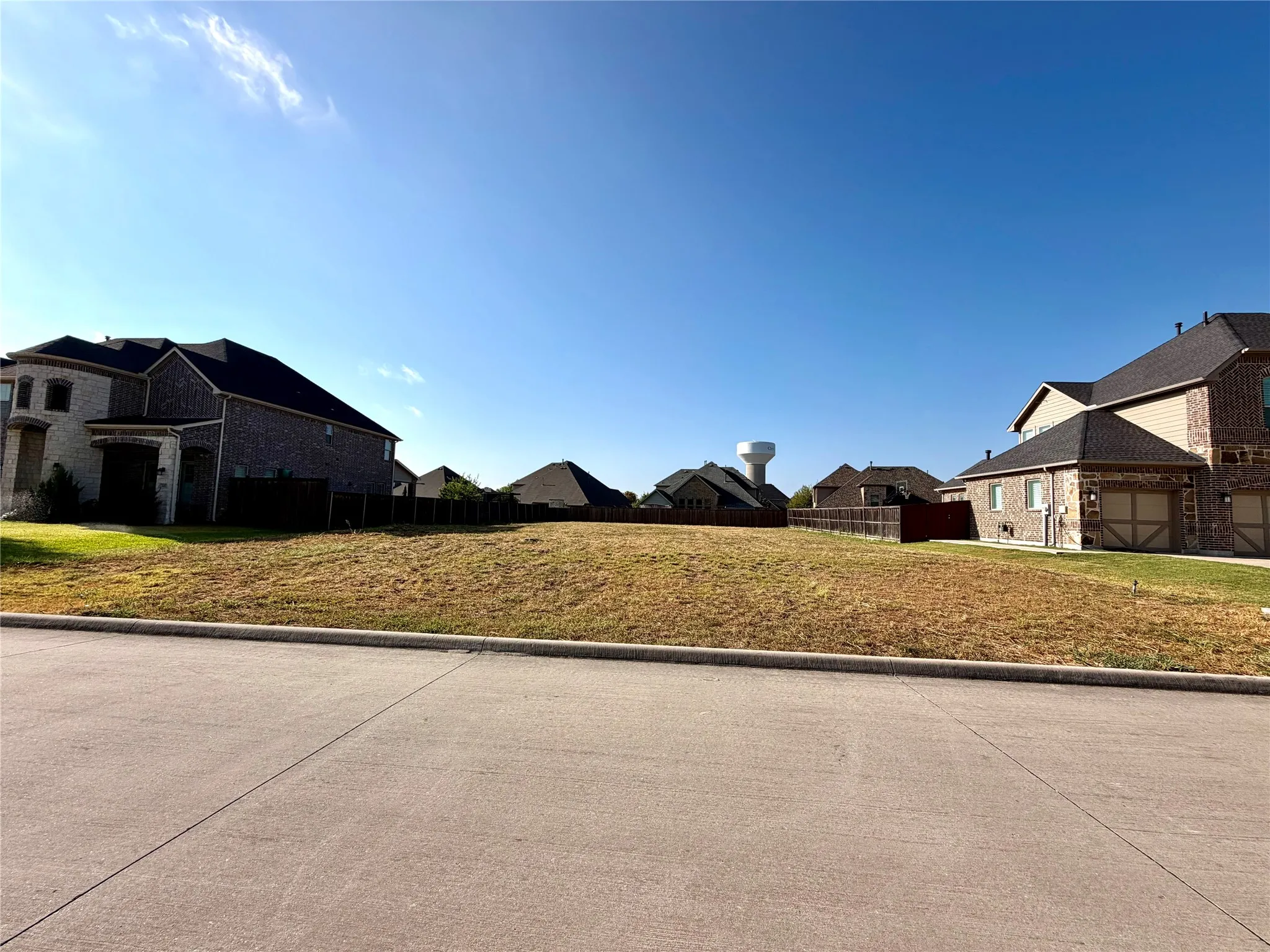 Expansive residential lot featuring a level terrain with surrounding established homes and paved street access