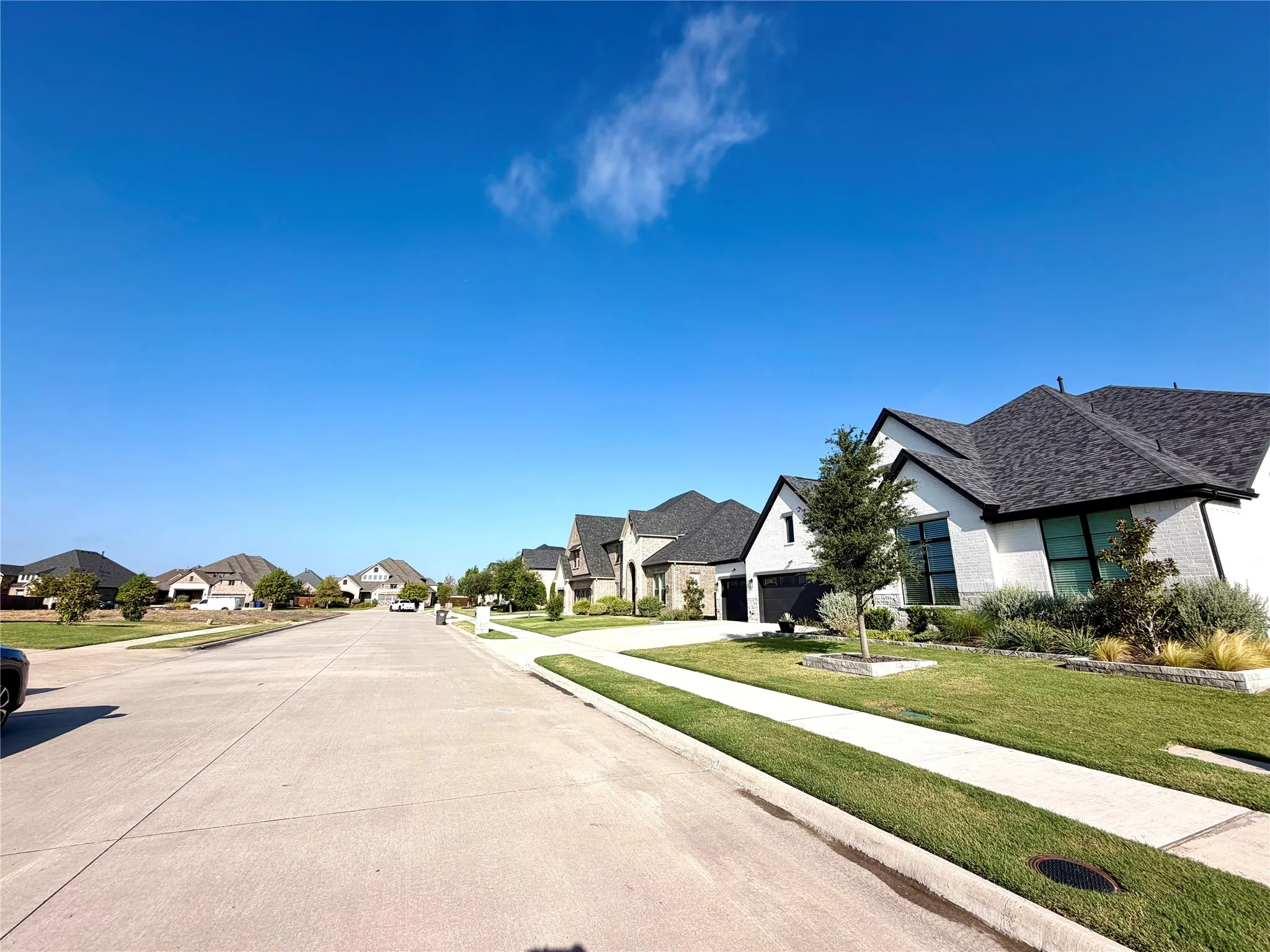 Contemporary exterior with a dark-pitched roof, white brick facade, and dark-framed windows
