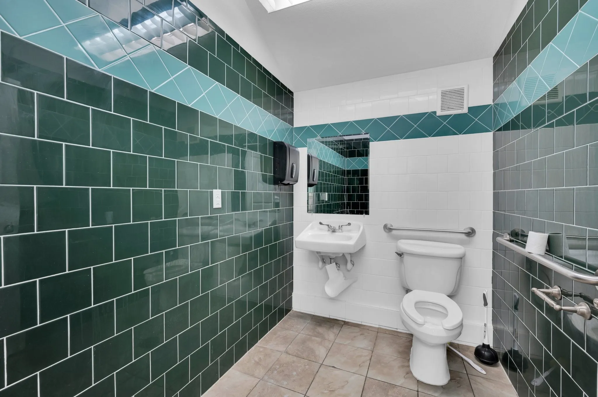 Restroom featuring dark green and light blue subway tile wainscoting with a white tile accent band
