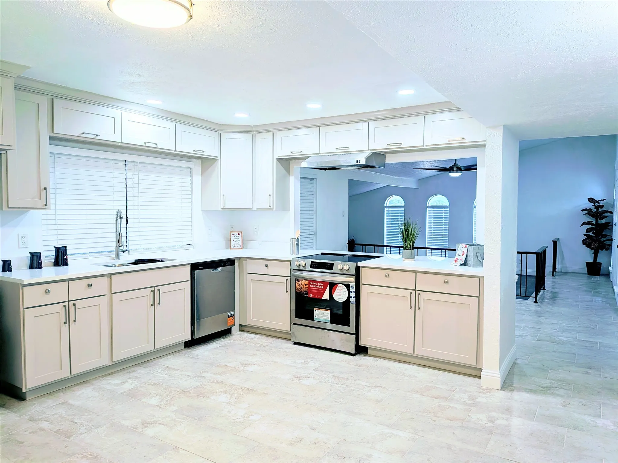 Kitchen featuring light-toned cabinetry, stainless steel appliances, a window with blinds, recessed lighting, and tile flooring