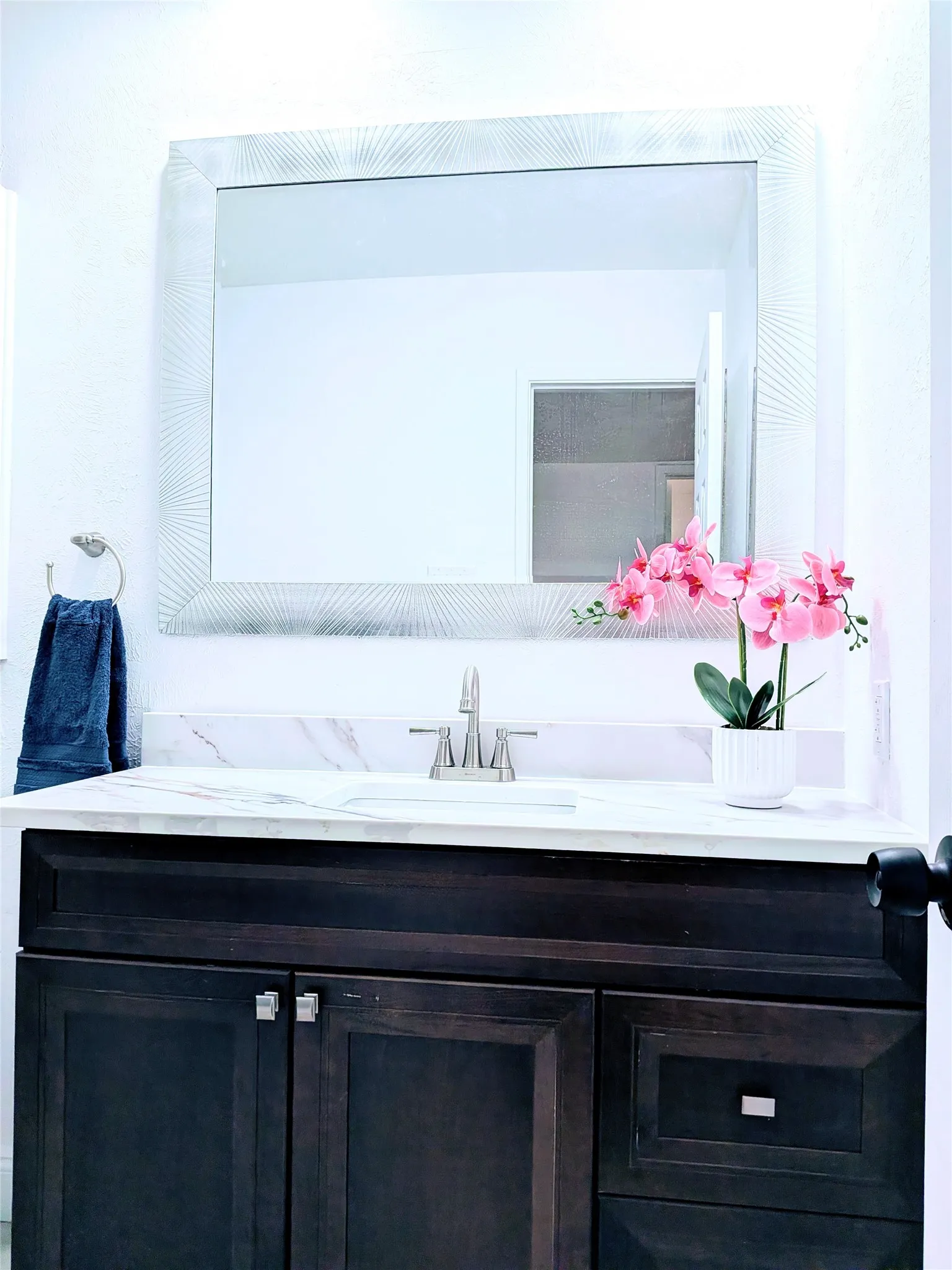 Dark wood-finish vanity with a white countertop and integrated sink