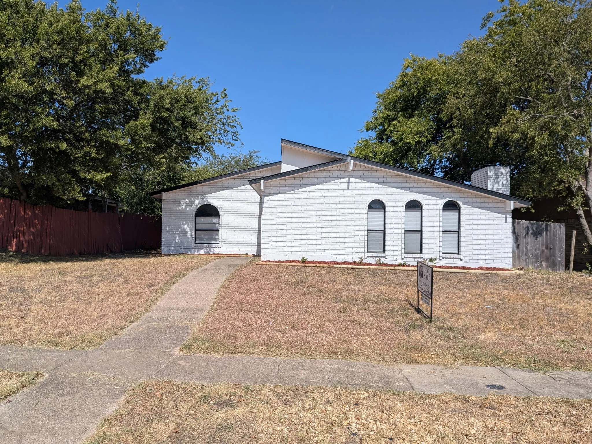 White brick exterior featuring an arched window and three arched windows