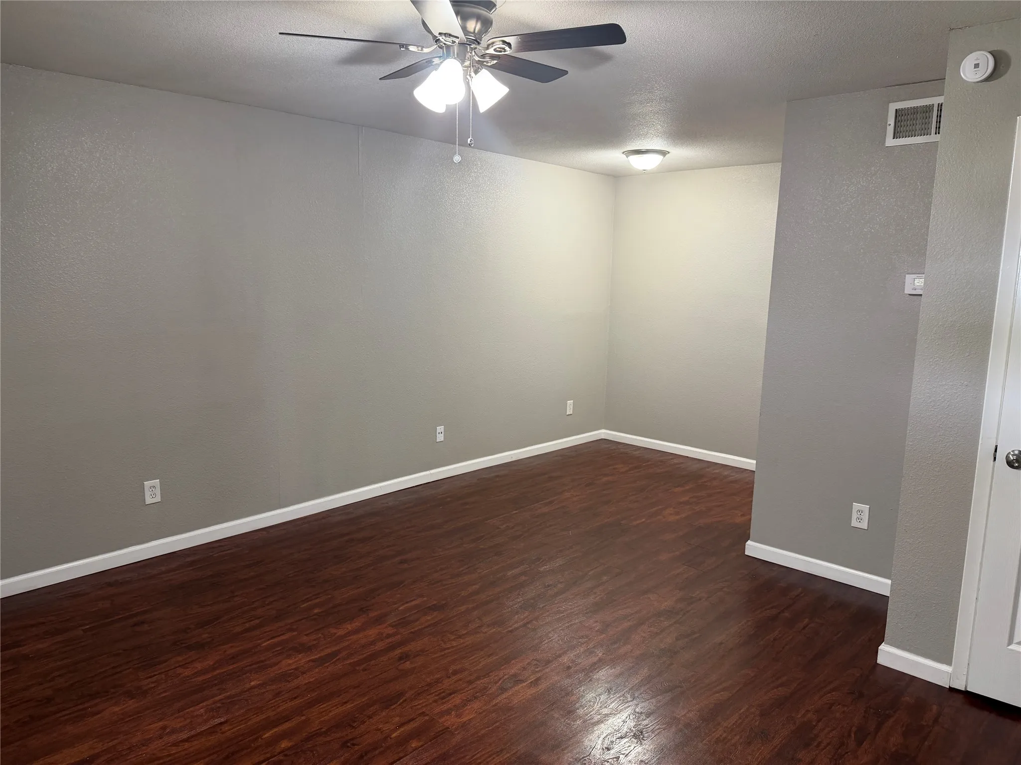 Wood-finish flooring, neutral wall tones, ceiling fan with integrated lighting, and recessed ceiling lighting