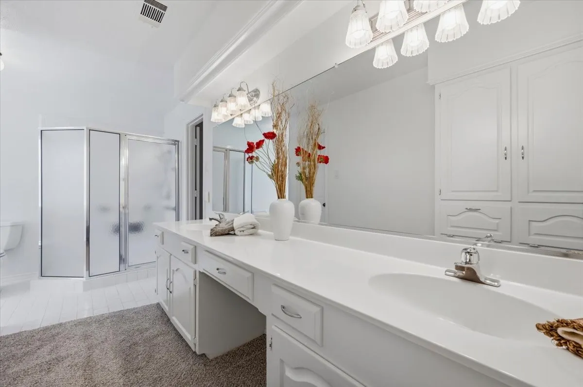 Featuring 2 sinks, walk-in-shower - wall of cabinets for linens and storage - lots of counter space  - view of large walk in shower
