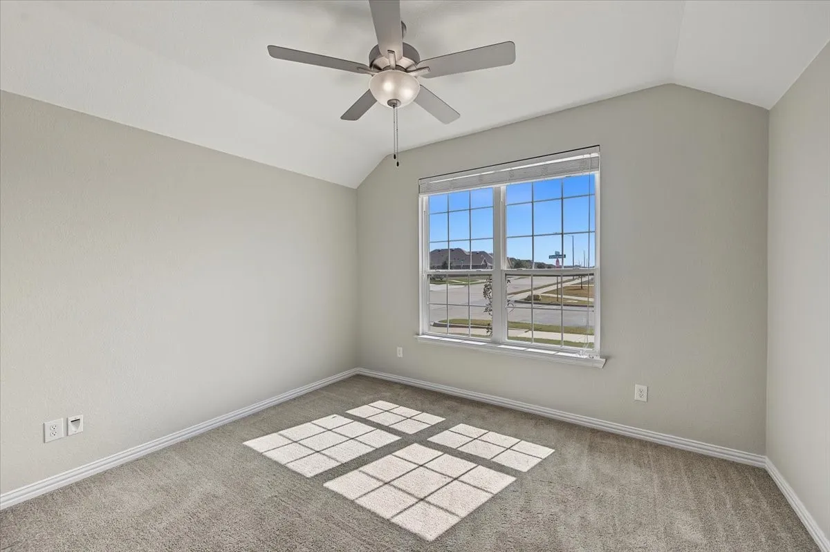 Vaulted ceiling with a ceiling fan, large window, and wall-to-wall​​‌​​​​‌​​‌‌​‌‌​​​‌‌​‌​‌​‌​​​‌​​ carpeting