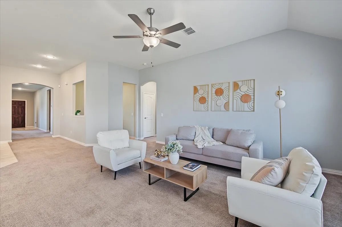 Vaulted ceiling with a ceiling fan, arched doorways, light-colored carpeting, and recessed lighting