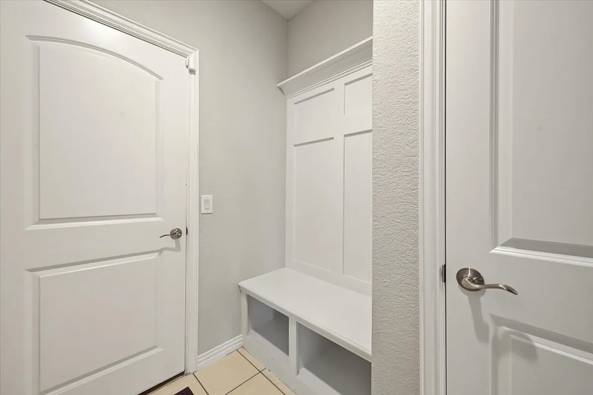 Built-in storage bench with paneling, multiple paneled doors, and contemporary hardware