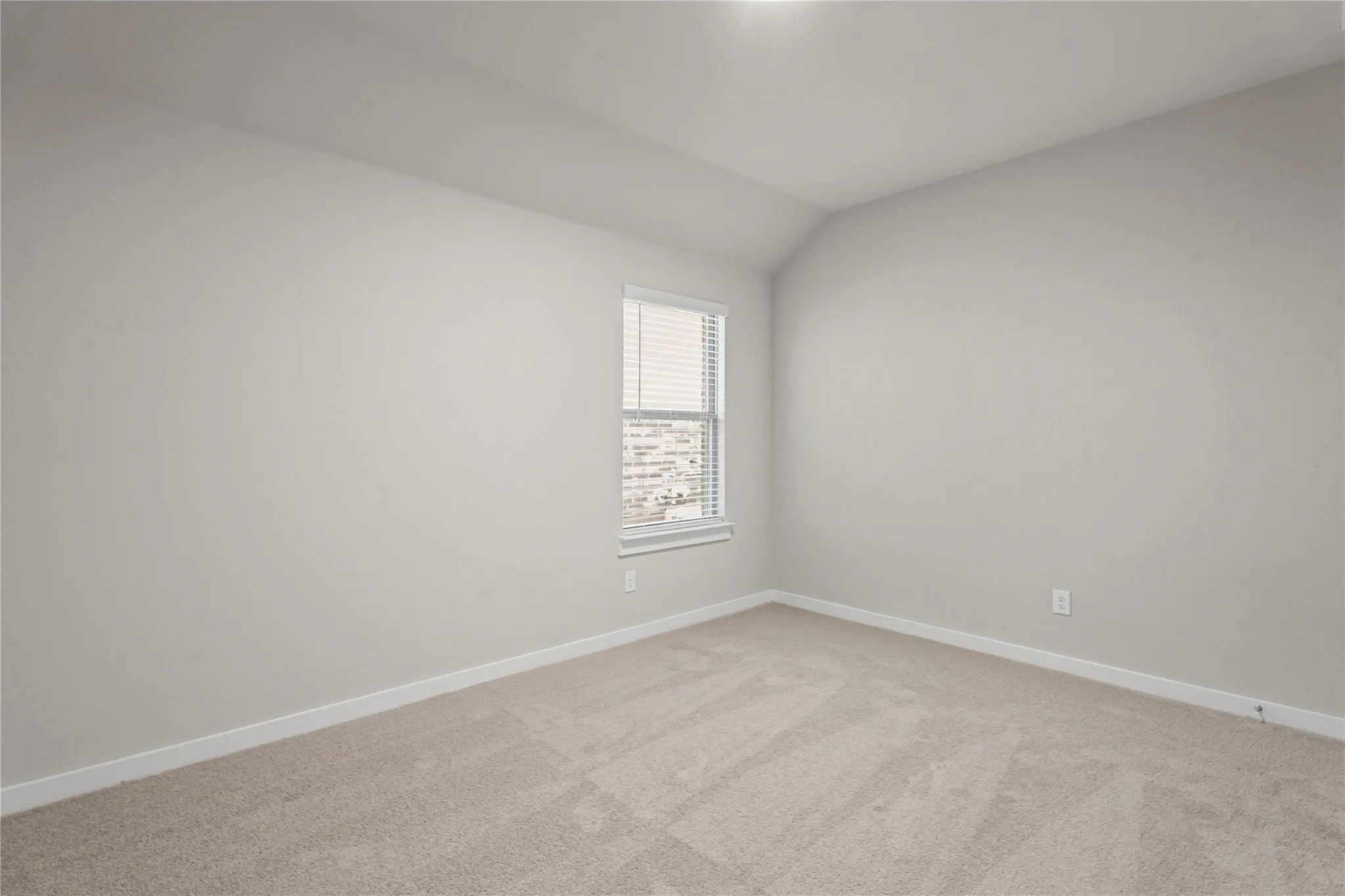 Neutral-toned carpeting, light wall paint, and a window with blinds