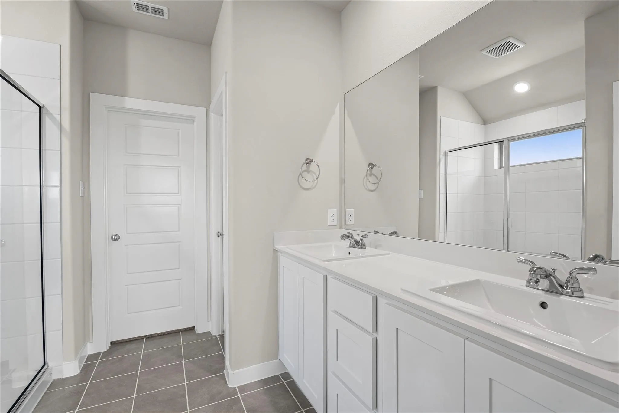 Dual sink vanity with white cabinetry and integrated sinks