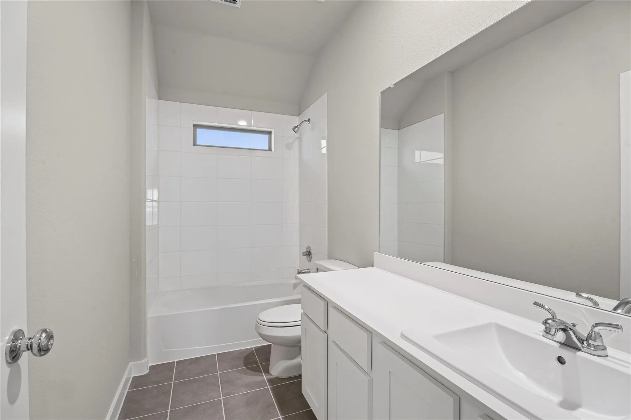 Bathroom with a white vanity, integrated sink, and chrome fixtures