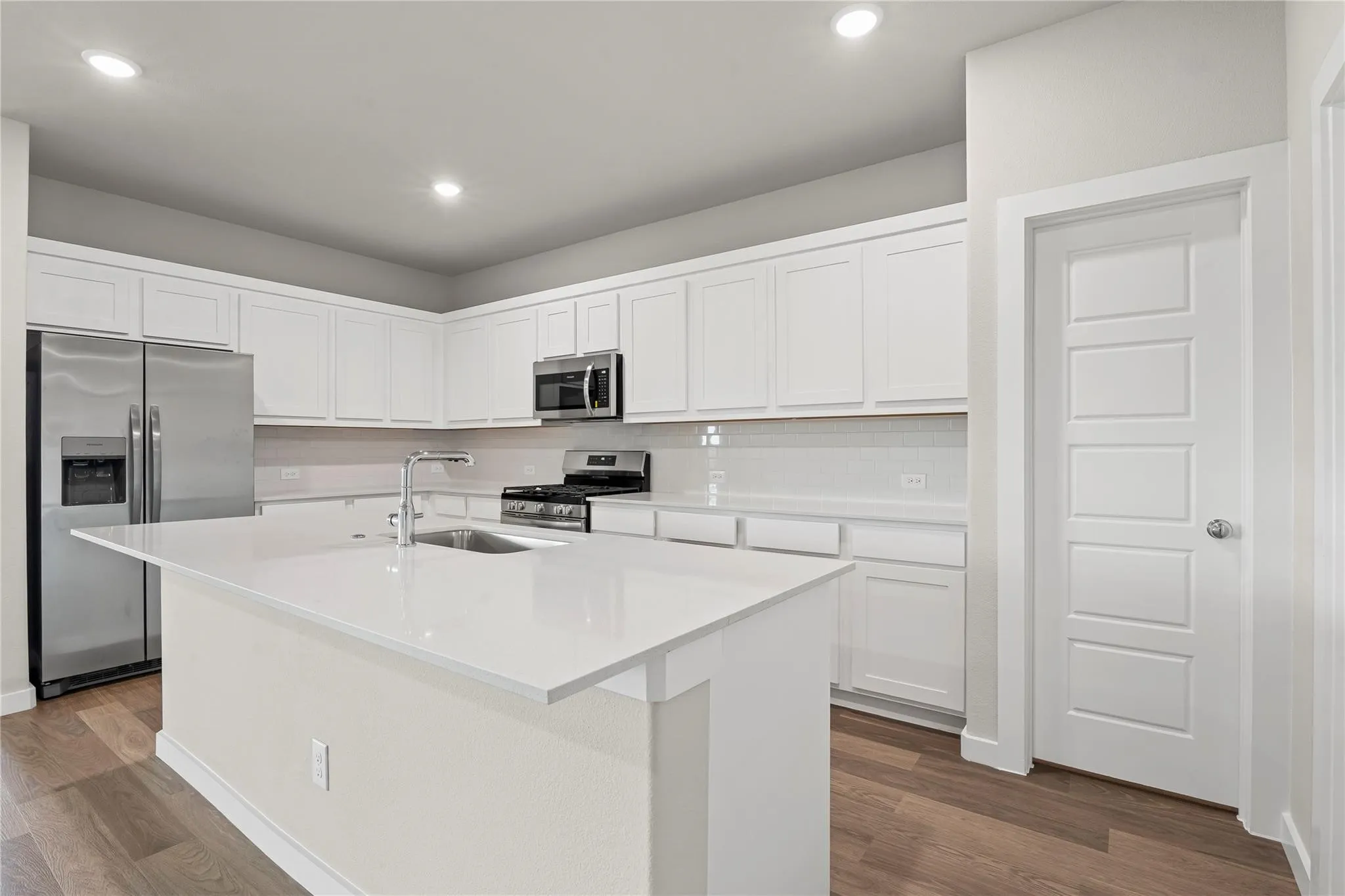Modern kitchen with white cabinetry and stainless steel appliances