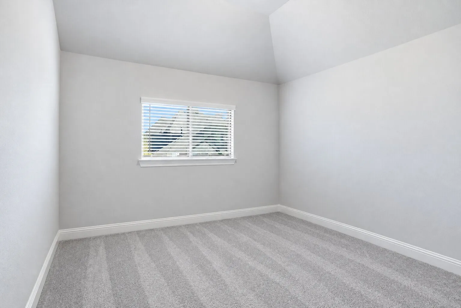 Upstairs secondary bedroom with a vaulted ceiling, natural light, freshly cleaned carpet, and convenient access to a full bathroom just down the hall. Photos have been AI enhanced for presentation; no material property features were altered.