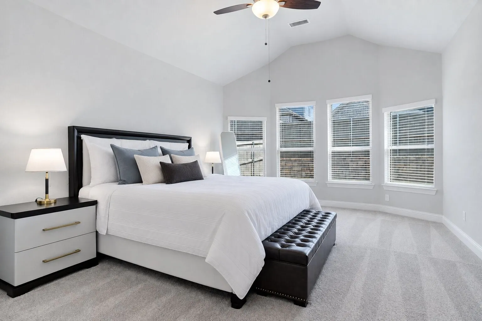 Spacious primary suite with a vaulted ceiling, abundant natural light, and plenty of room for additional seating or furniture. Photos have been AI enhanced for presentation; no material property features were altered.