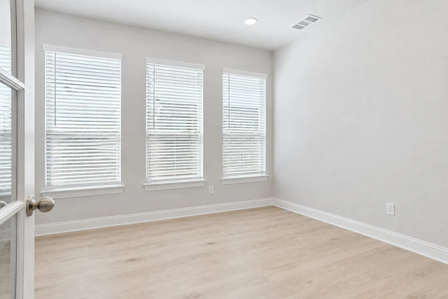 Light-filled office with French doors and three large windows—also ideal as a sitting room, second living area, or formal dining room. Photos have been AI enhanced for presentation; no material property features were altered.