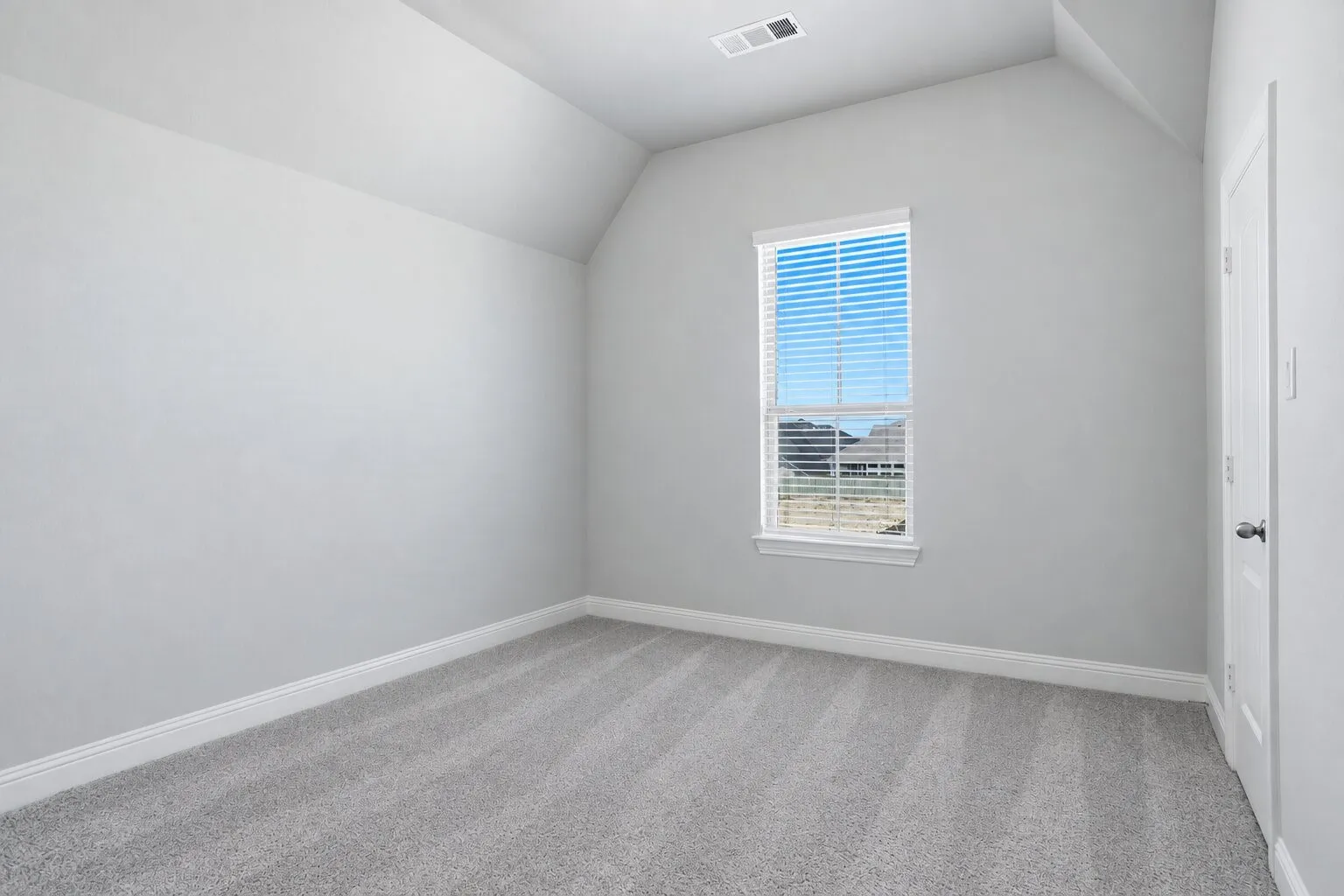 Bright upstairs secondary bedroom featuring a large window, freshly cleaned carpet, and a private en suite full bathroom. Photos have been AI enhanced for presentation; no material property features were altered.
