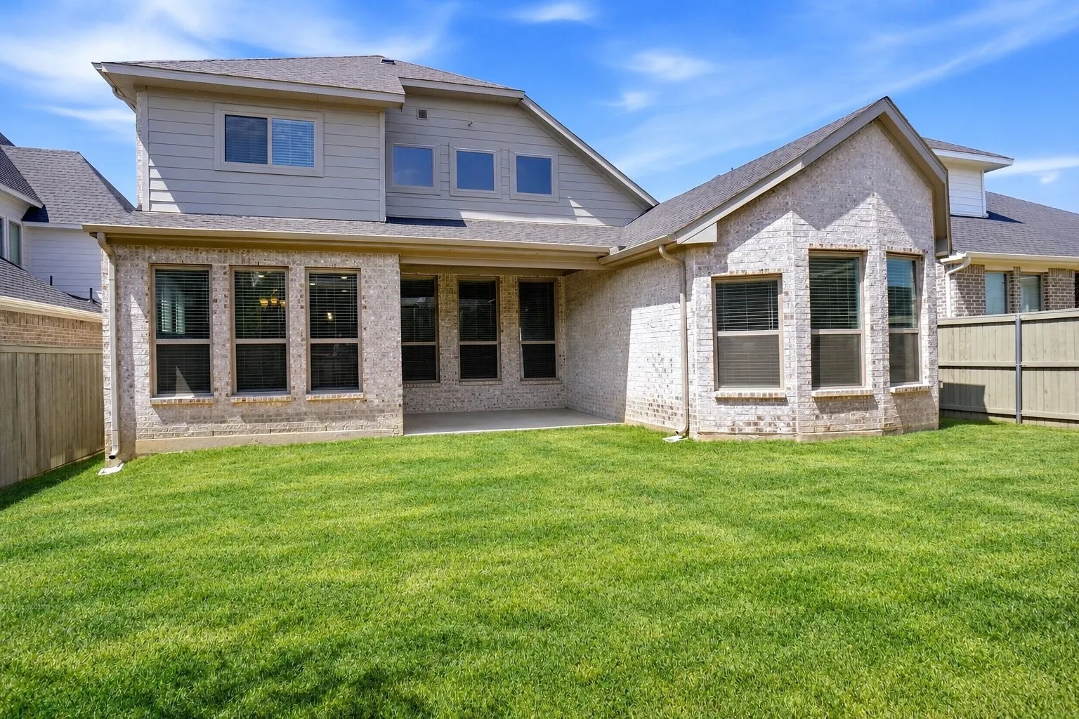 Spacious, fully fenced backyard featuring a covered patio, lush lawn, and plenty of room for outdoor entertaining, play, or future enhancements. Photos have been AI enhanced for presentation; no material property features were altered.