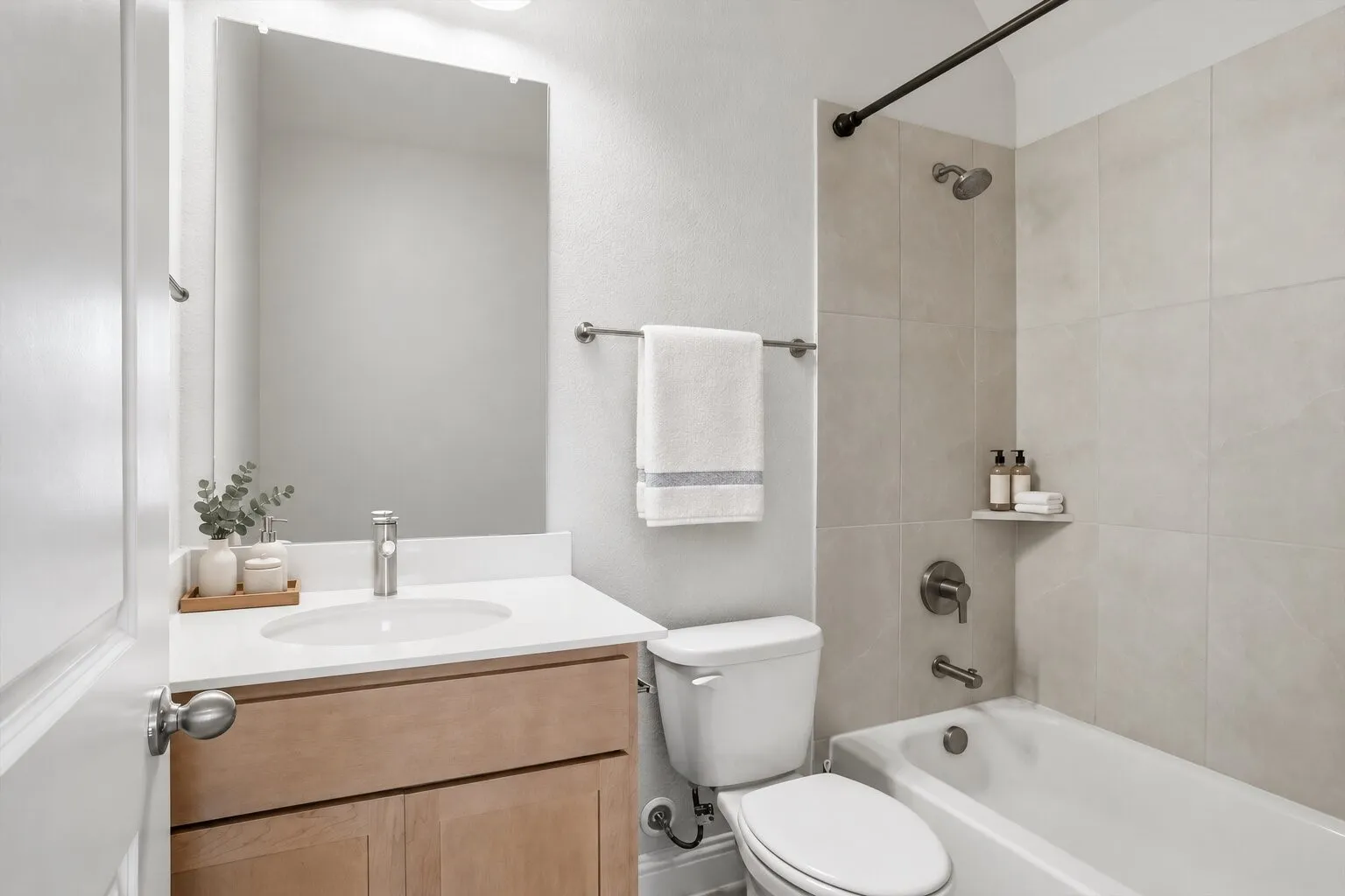 Upstairs en suite full bathroom featuring a tub-and-shower combination, spacious vanity, and ample storage. Photos have been AI enhanced for presentation; no material property features were altered.