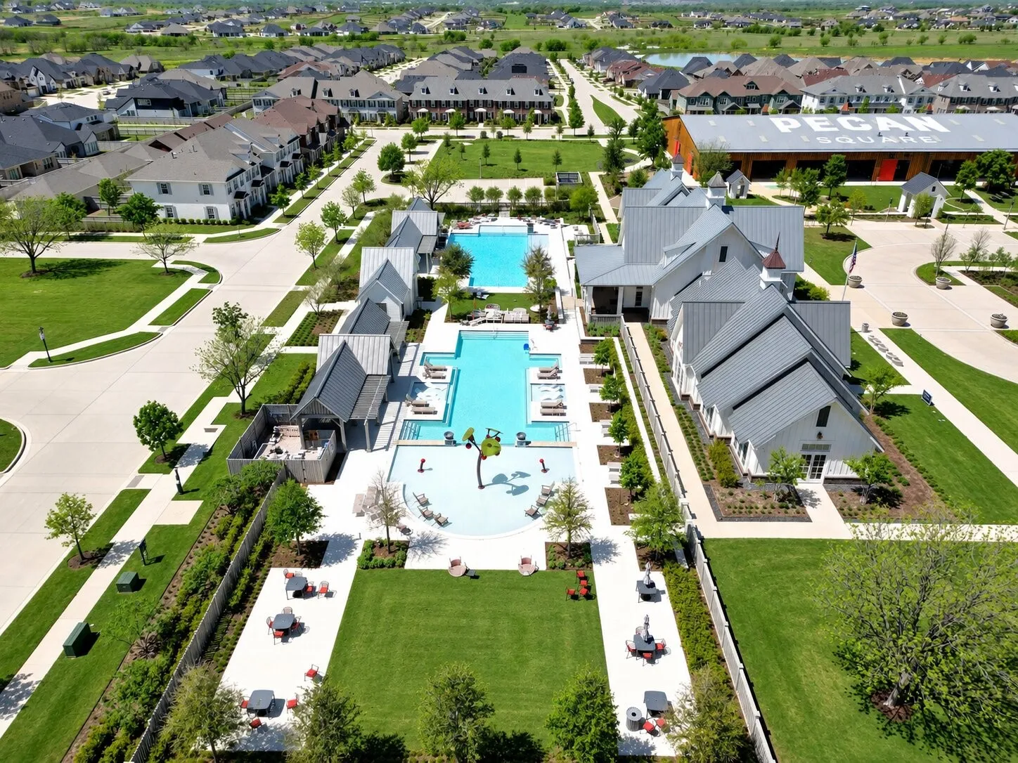 Pecan Square’s resort-style pool complex features multiple pools, lounge areas, a splash zone, and inviting outdoor spaces designed for recreation and relaxation.