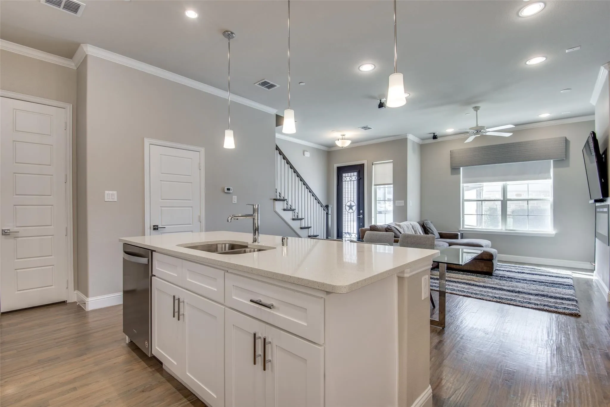 Kitchen island featuring a stainless steel sink and integrated dishwasher