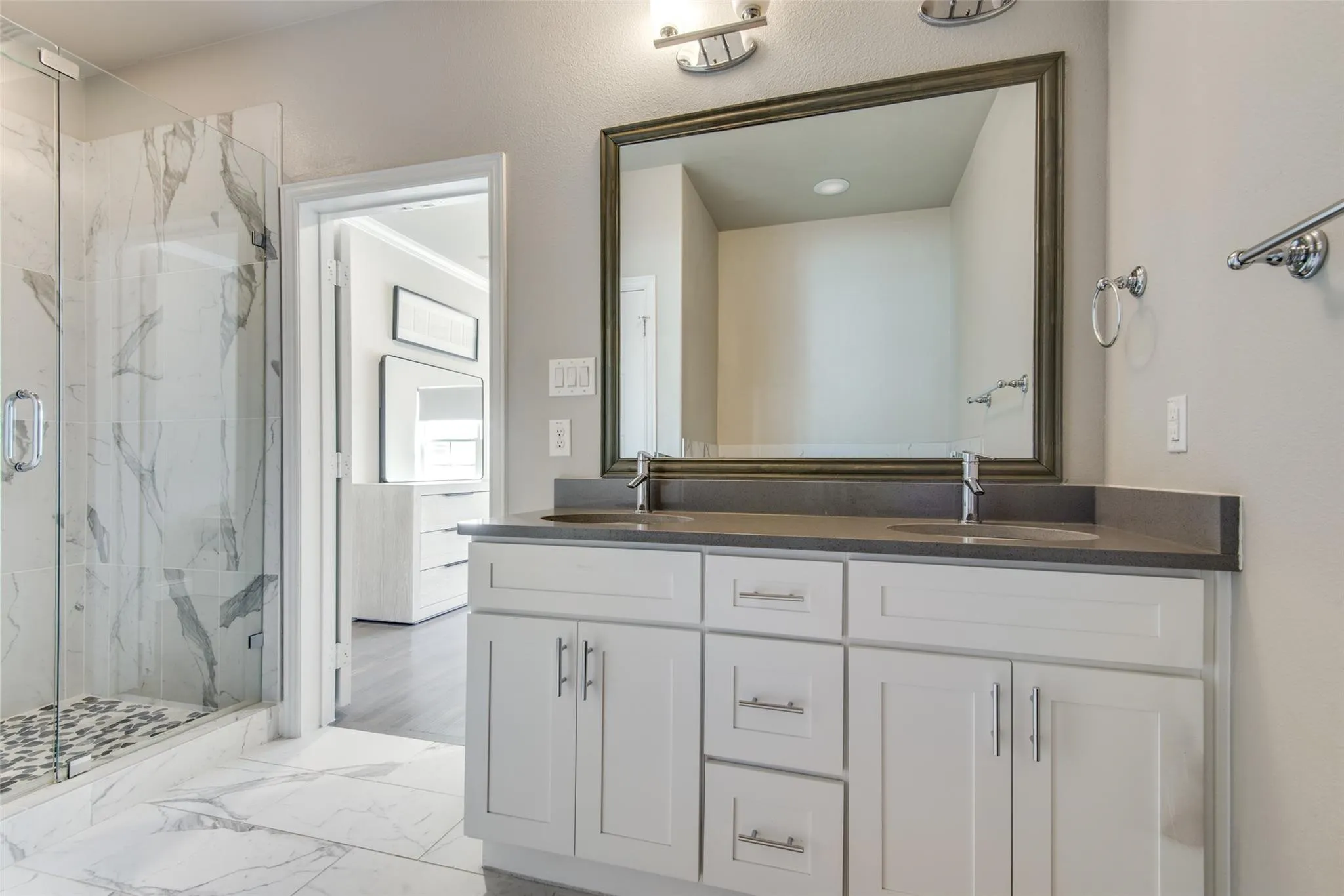 Dual vanity with undermount sinks, gray countertop, and framed mirror