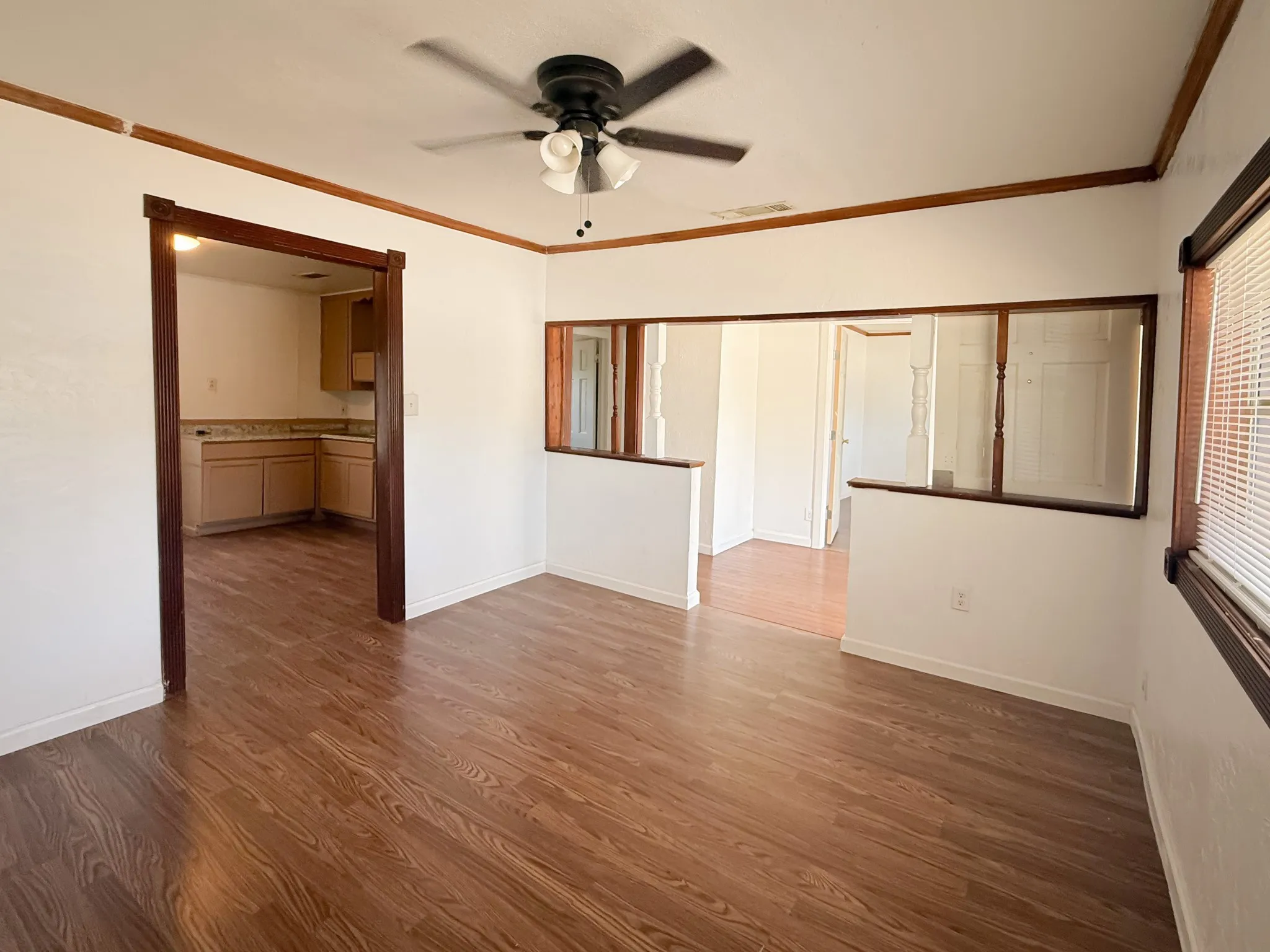 Wood-finish flooring throughout, complemented by a ceiling fan with integrated lighting